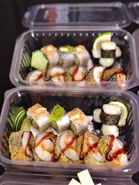 two plastic containers with sushi in them