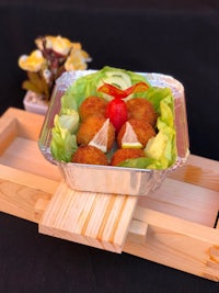 japanese fried chicken in a container on a wooden tray