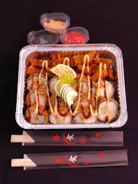 a tray of sushi with chopsticks and chopsticks