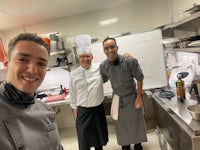 three chefs posing for a photo in a kitchen