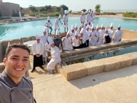 a group of chefs posing for a photo in front of a pool