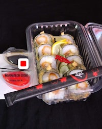 sushi in a plastic container with a knife and chopsticks